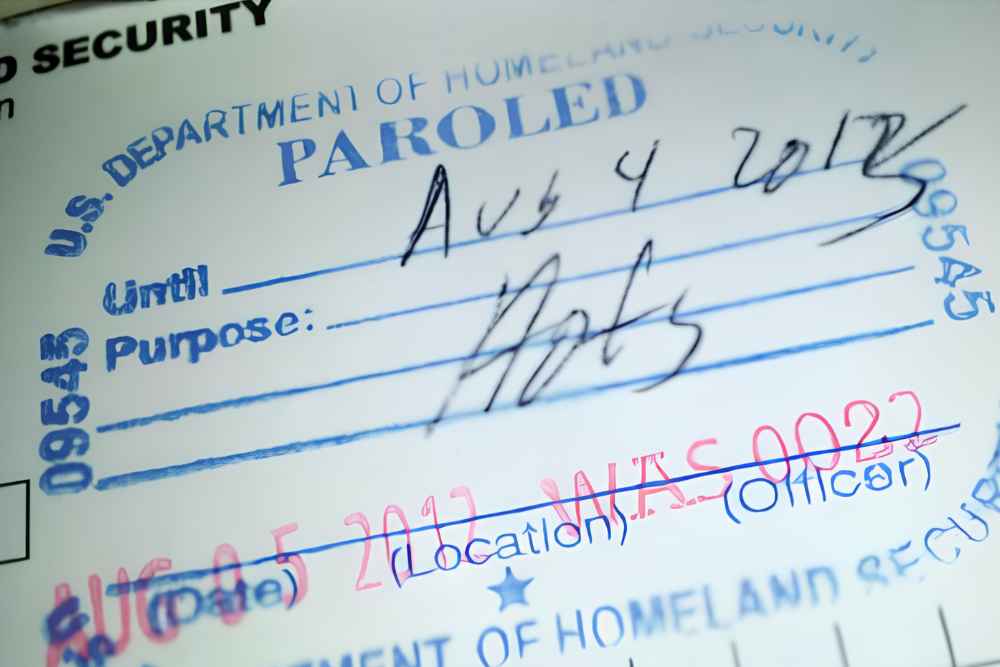 Close-up of a DHS paroled admission stamp illustrating advance parole travel risks.